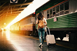 En kvinna drar en resväska på tågperrongen